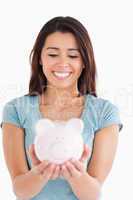 Good looking woman posing with a piggy bank