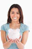 Gorgeous woman posing with a piggy bank