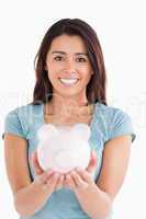 Lovely woman posing with a piggy bank