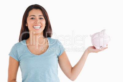 Beautiful female holding a piggy bank