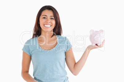 Attractive female holding a piggy bank