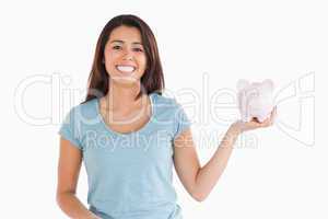 Attractive female holding a piggy bank