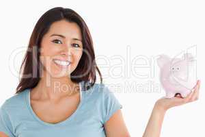 Lovely female holding a piggy bank