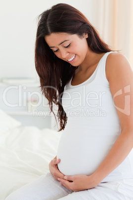 Portrait of a beautiful pregnant woman touching her belly while