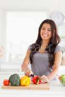 Charming woman cooking vegetables while standing