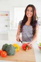 Beautiful female cooking vegetables while standing