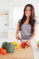 Pretty female cooking vegetables while standing