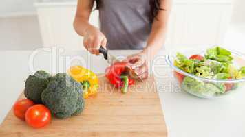 Young female cooking vegetables while standing