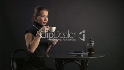 woman drinks coffee and speaks by phone