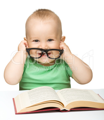 Little child play with book and glasses