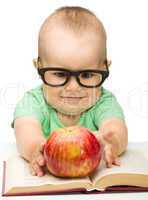 Little child is playing with red apple