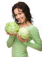 Beautiful young girl with two green cabbages