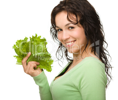 Beautiful young girl with green lettuce leaf