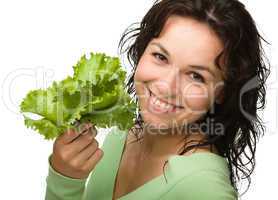 Beautiful young girl with green lettuce leaf