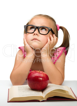 Little girl is sitting bored with a book