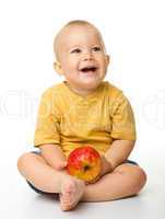 Cheerful little boy with red apple