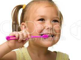 Little girl is cleaning teeth using toothbrush