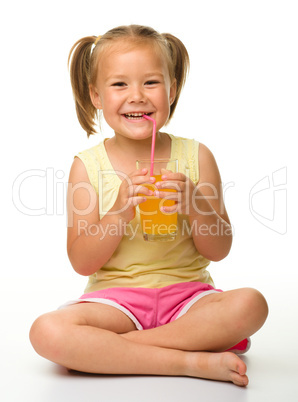 Little girl drinks orange juice