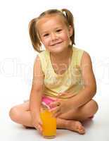 Little girl drinks orange juice