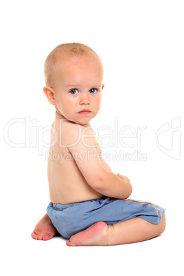 Baby in blue shorts, sitting on his knees