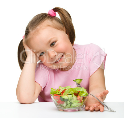 Cute little girl eats vegetable salad