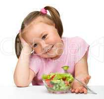 Cute little girl eats vegetable salad