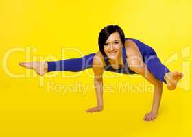 woman stand on hands in yoga pose - blue on yellow