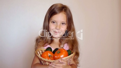 Little girl with tomatoes and cucumbers