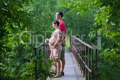 Husband with his pregnant wife on the bridge