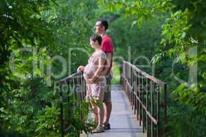 Husband with his pregnant wife on the bridge