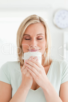 Woman taking in smell of coffee with eyes closed