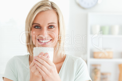 Close up of a woman taking in smell of coffee looking into the c