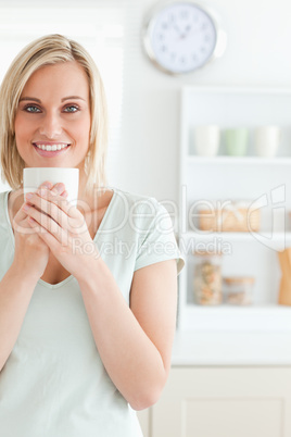 Portrait of a woman taking in smell of coffee looking into the c