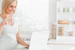 Smiling woman with a cup of coffee and a laptop