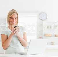 Cute woman with mobile and laptop smiling