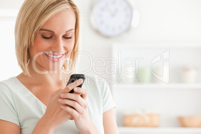 Close up of a cute woman smiling at her mobile