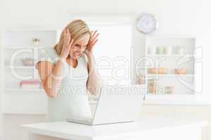 Upset woman looking at her laptop