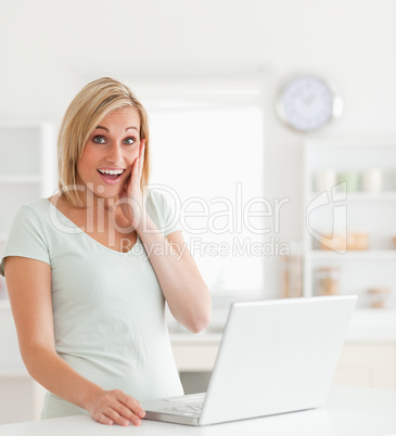 Amazed blonde woman with a notebook looking into the camera