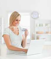 Blonde woman with credit card and notebook