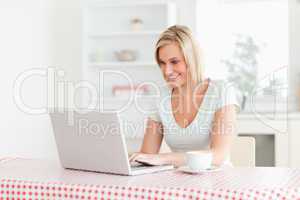 Woman sitting at table with cup of coffee and notebook