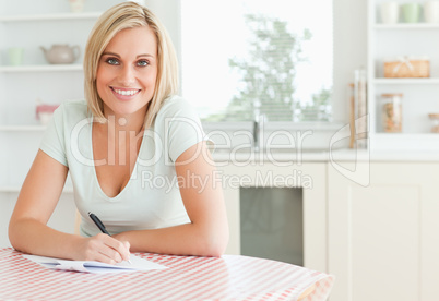 Charming woman proof-reading a text looks into camera