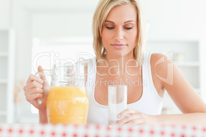 Close up of a woman sitting at a table with orange juice and gla