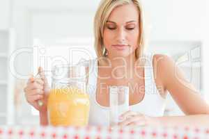 Close up of a woman sitting at a table with orange juice and gla