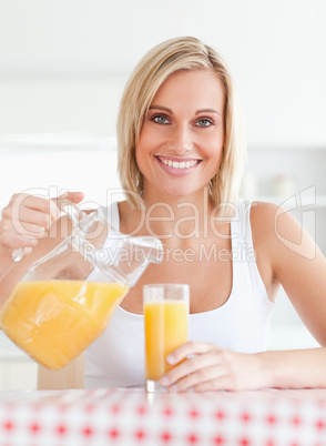 Close up of a smiling woman sitting at a kitchentable filling or