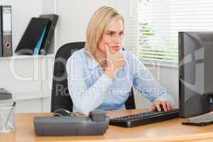 Working thoughtful woman in front of a screen looking at it