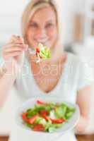 Smiling woman offering salad