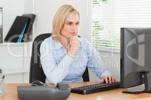 Working serious woman in front of a screen looking at it