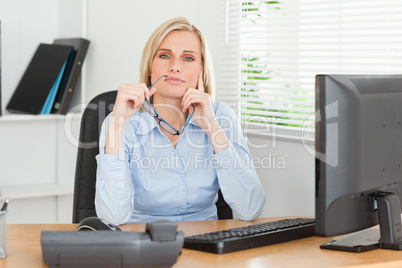 Thoughtful woman with glasses looking into camera