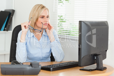 Serious thoughtful woman with glasses looking at screen