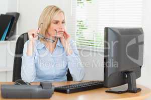 Serious thoughtful woman with glasses looking at screen